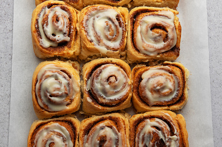 Delicious cinnamon rolls with cream cheese frosting on baking pa, a Food & Drink Photo by Olena Rudo
