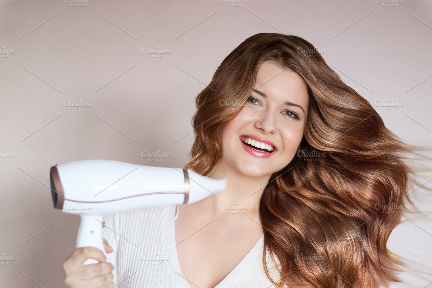 Happy young woman blow drying her long, shiny brown hair, achiev, a Person Photo by Studio ANNA