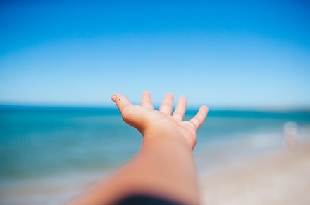 Closeup hand on background of the sea and sky, a Person Photo by travnikovstudio