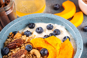 Healthy autumn breakfast bowl with yogurt, granola, nuts, baked, a Food & Drink Photo by Rimma