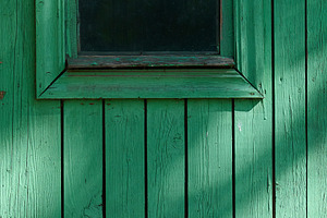 A fragment of an old wooden wall with a small window painted gre, a Nature Photo by ndanko