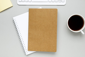Simple desk arrangement with coffee cup, eyeglasses and notebook forming quiet, a Photo by matucha