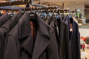 Winter coats hanging on retail rack in clothing store, offering warmth and styl, a Photo by Studio ANNA