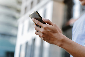 A man using a smartphone in an urban environment, representing m, a Technology Photo by salmon.black