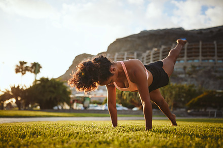 Fit woman in sportswear doing yoga alone in a park
