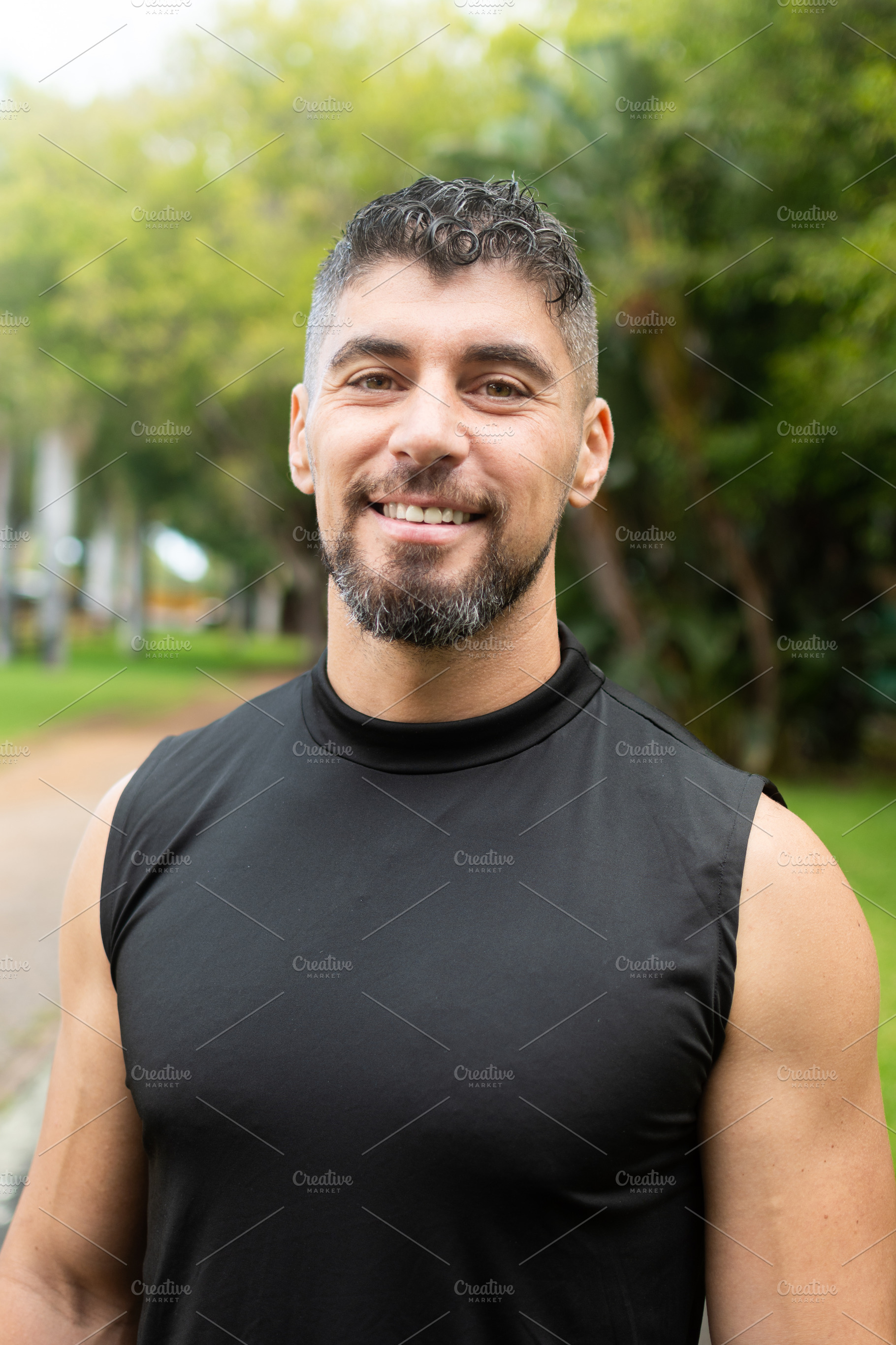 Confident male personal trainer smiling at camera outdoors in park, a Sports & Recreation Photo by etorres69