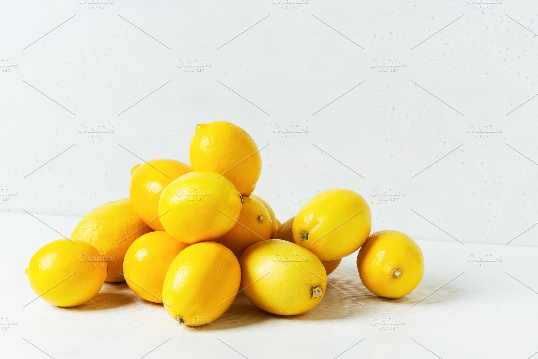 Heap of lemons on white table, a Food & Drink Photo by AlinaKho