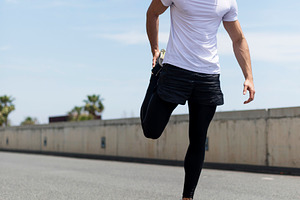 Title: Athletic man stretching outdoors before running, a Person Photo by RF Images