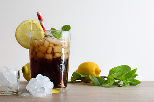 Refreshing cola drink with mint and lemon on wooden table, a Food & Drink Photo by Davizro's Market