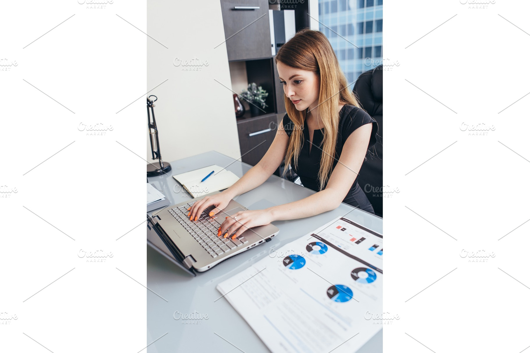 Woman working with documents sitting at desk in office containing, a Business Photo by undrey