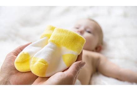 Mother puts socks on the little baby, a Person Photo by yanadjana