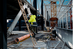 Construction worker climbing the, an Industrial Photo by HalfPoint