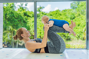 Mother doing fitness exercises while, an Architecture Photo by Elizaveta Galitskaya