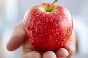 Close up of a fresh red apple held, a Food & Drink Photo by MistyDay