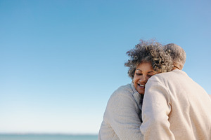Affectionate senior woman smiling while leaning on her husband