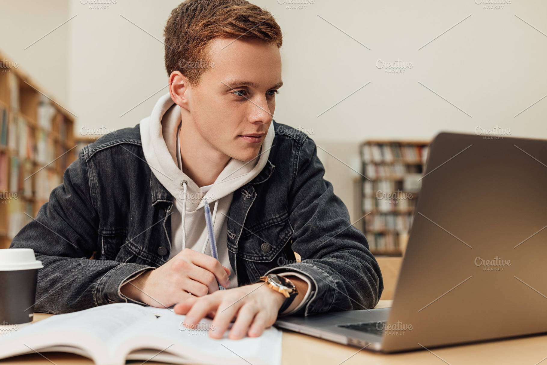 Male student in a library reading, a Person Photo by Artem Varnitsin