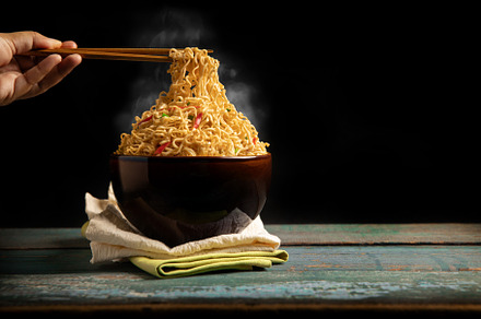 Bow of Hot Boiled Instant Noodles on the Table. Hand Using Chops, a Food & Drink Photo by salmon.black