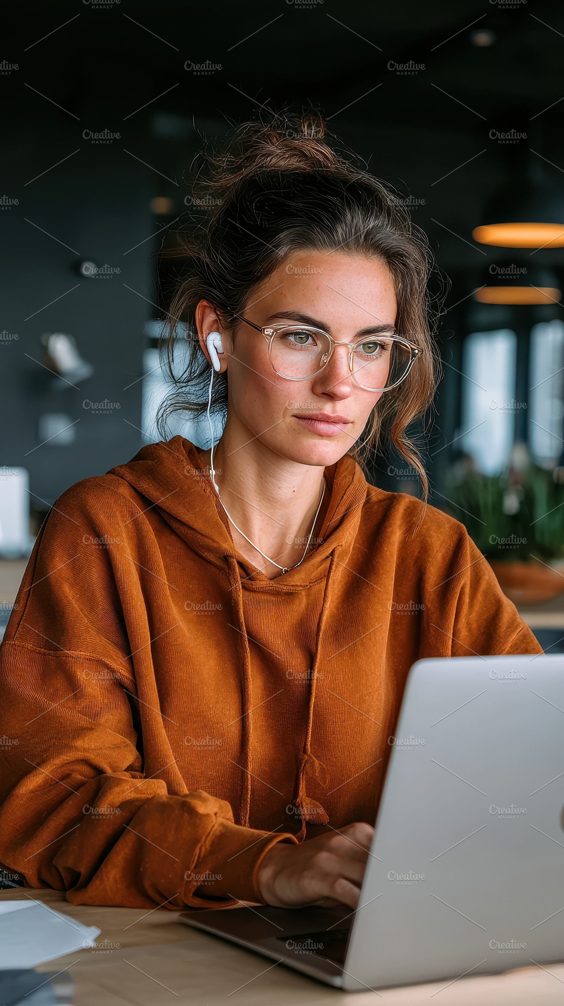 Woman working on laptop wearing glas, a Photo by Pixeness Studio