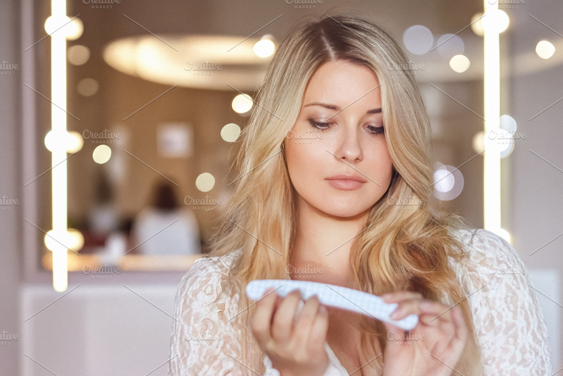 Blonde woman shaping nails with a file, doing manicure and self, a Person Photo by Studio ANNA