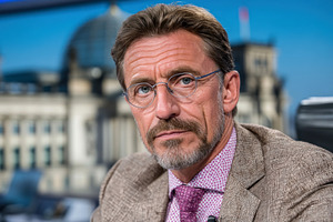 Mature businessman with glasses and beard in formal attire seate, a Photo by José Manuel Gelpi