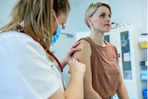 Doctor administering vaccine to, a Health & Medical Photo by HalfPoint