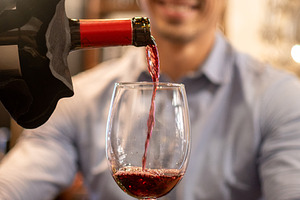 Pouring red wine into glass during romantic restaurant dinner, a Person Photo by etorres69