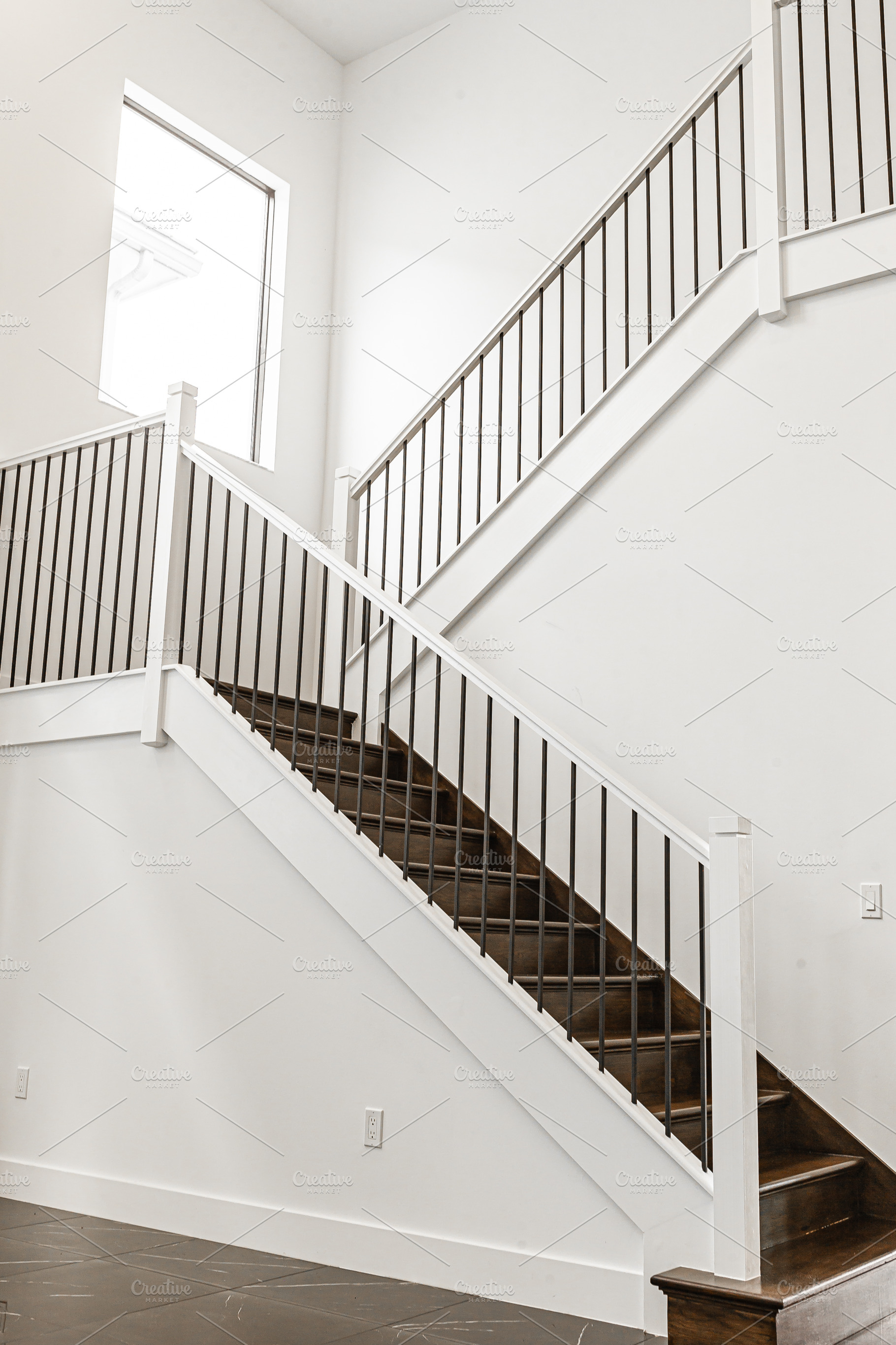 Modern white wooden staircase in new house interior with big windows, a Person Photo by travnikovstudio