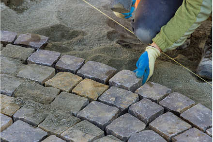 Road master of gloves lays paving, an Industrial Photo by Ungvar Studio
