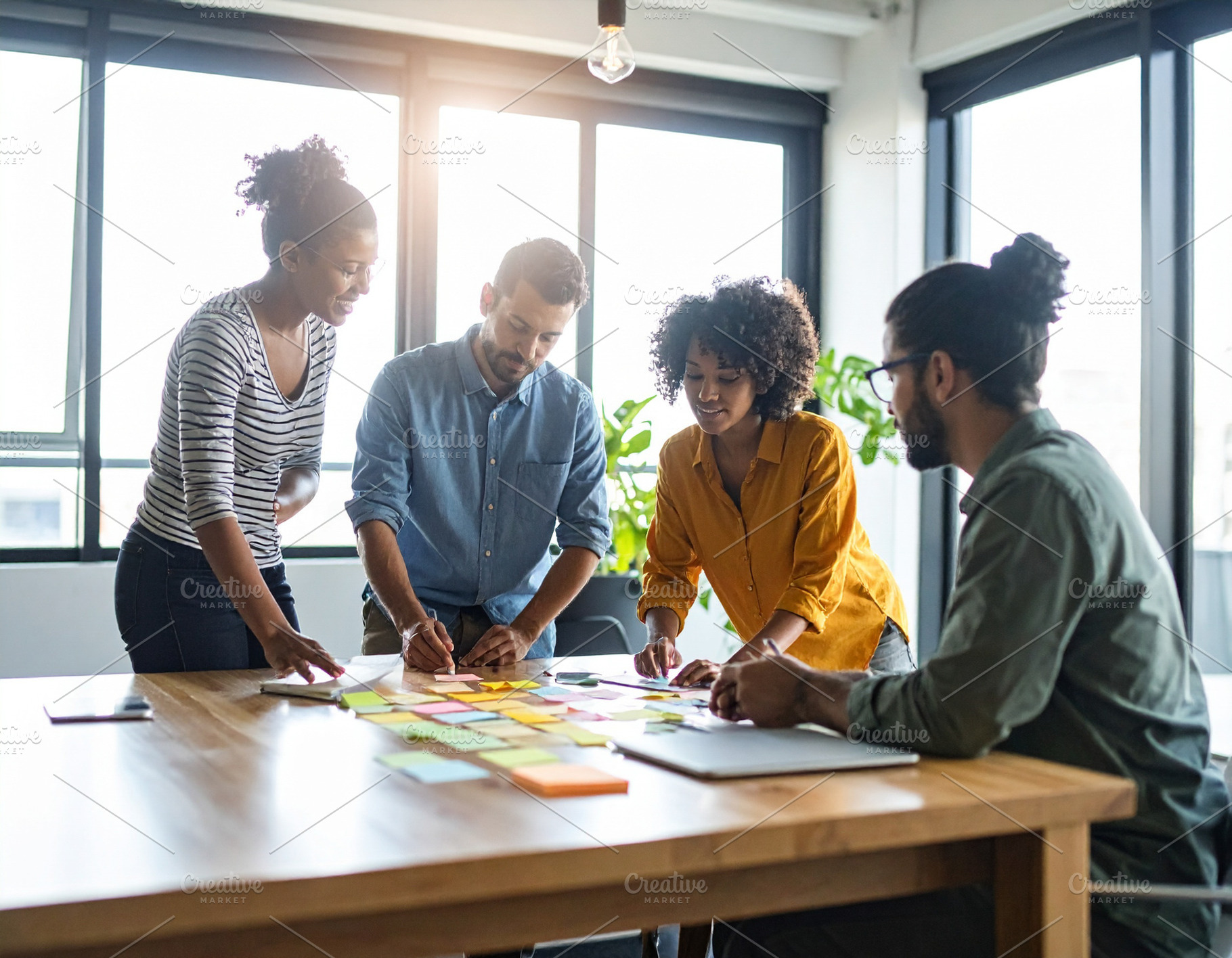 Young professionals engaged in a brainstorming session around a, a Business Photo by DanFLCreativo