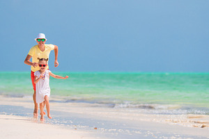 Happy family on beach vacation featuring adult, baby, and run