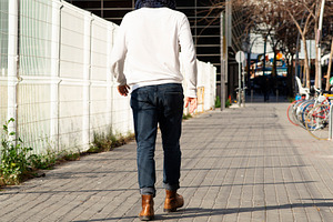 Young caucasian man walking away on urban sidewalk, a Person Photo by RF Images