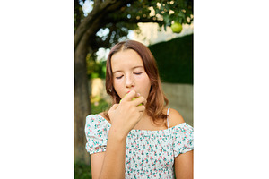 Girl eating a pear while standing in, a Nature Photo by IlliaBondarPhotography