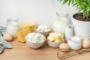 Assortment of fresh dairy products on wooden table, a Food & Drink Photo by Olena Rudo