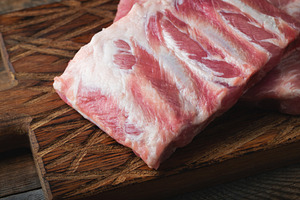 Raw pork ribs with spices, salt and rosemary on dark wooden background, a Food & Drink Photo by Budarinphoto