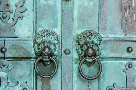 Part of a historic metal green door