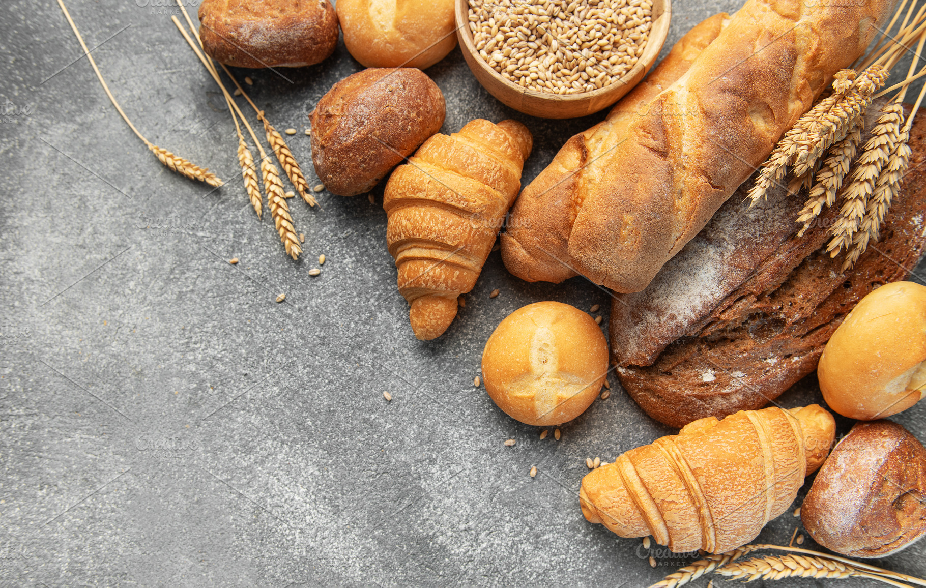 Assortment of fresh bread and pastries on gray background, a Food & Drink Photo by Olena Rudo