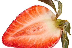 Longitudinal section of ripe strawberry with green leaves on an, a Food & Drink Photo by ndanko