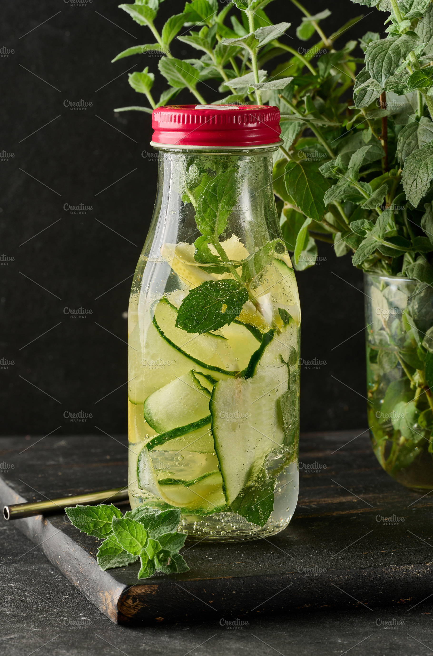Glass bottle filled with detox water containing cucumber and lem, a Food & Drink Photo by ndanko