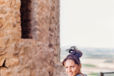 Woman leaning on a railing next to historic castle, a Holiday Photo by Iván Moreno STOCK PHOTO