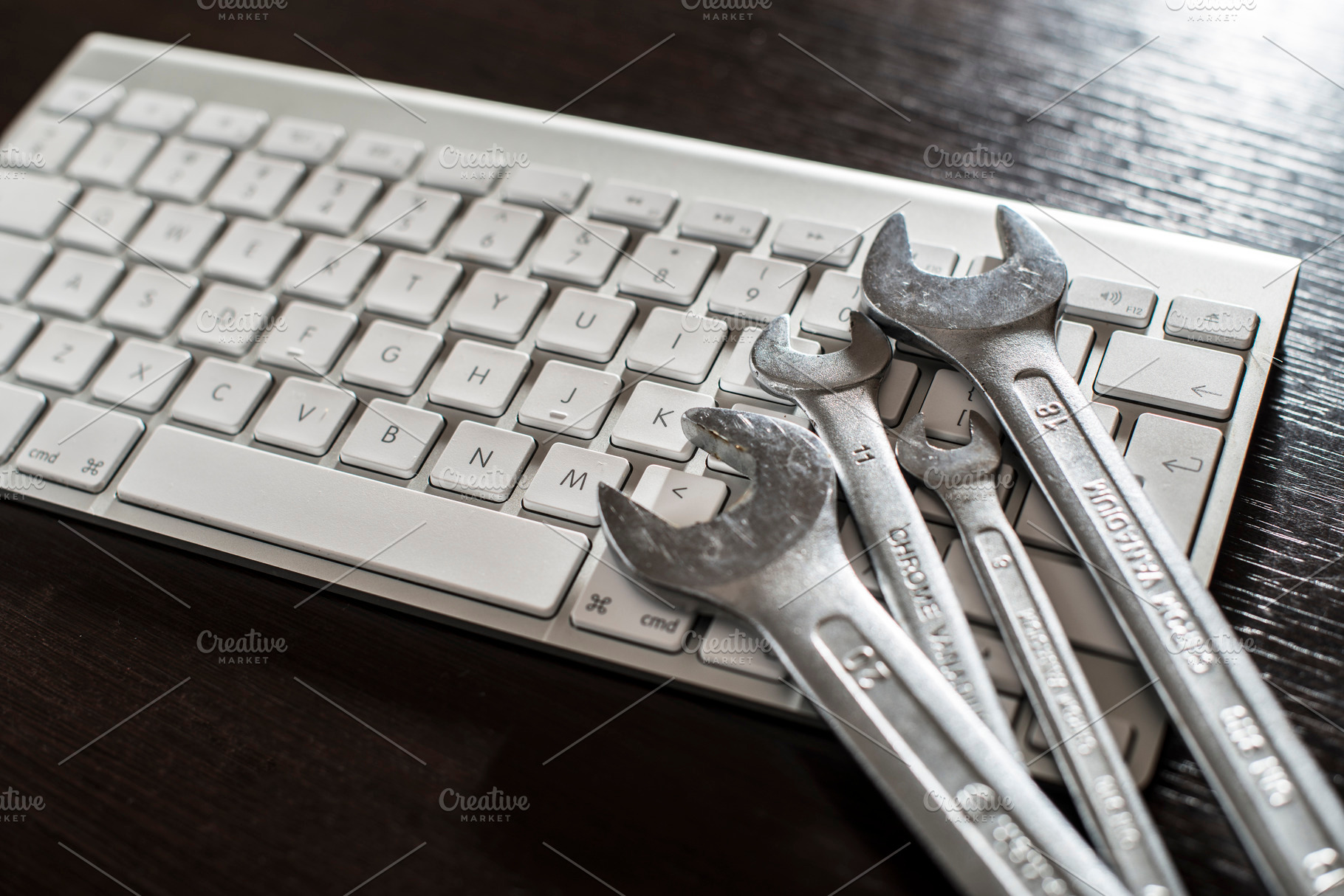 Spanners and white keyboard containing computer, support, and keyboard, a Technology Photo by DegImages