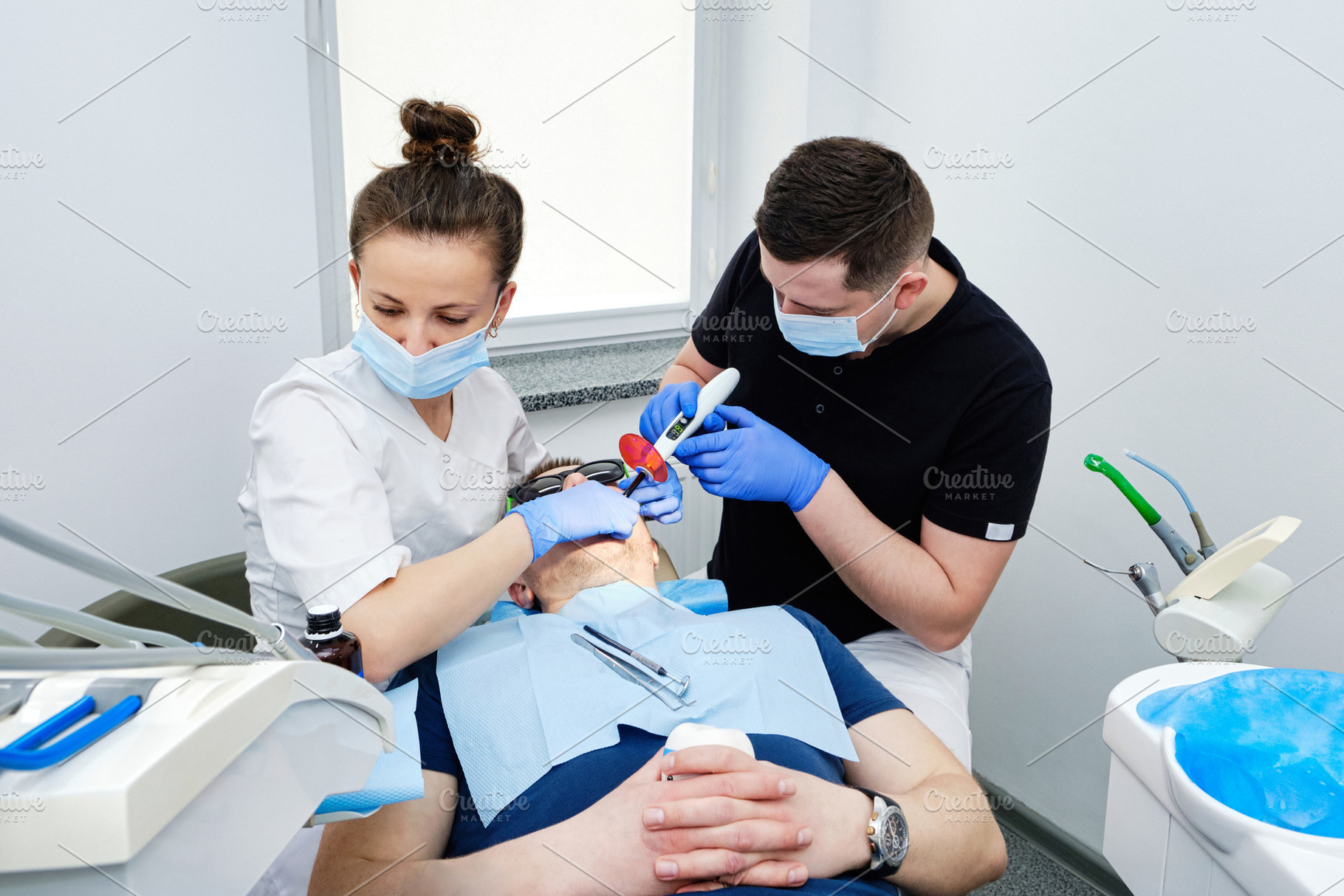 Dental Curing Light: Polymerization Process. Dentist and assistant applying fil, a Health & Medical Photo by Rohan Photography