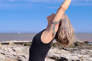 Woman practices yoga on a rugged rocky surface, a Person Photo by DanFLCreativo
