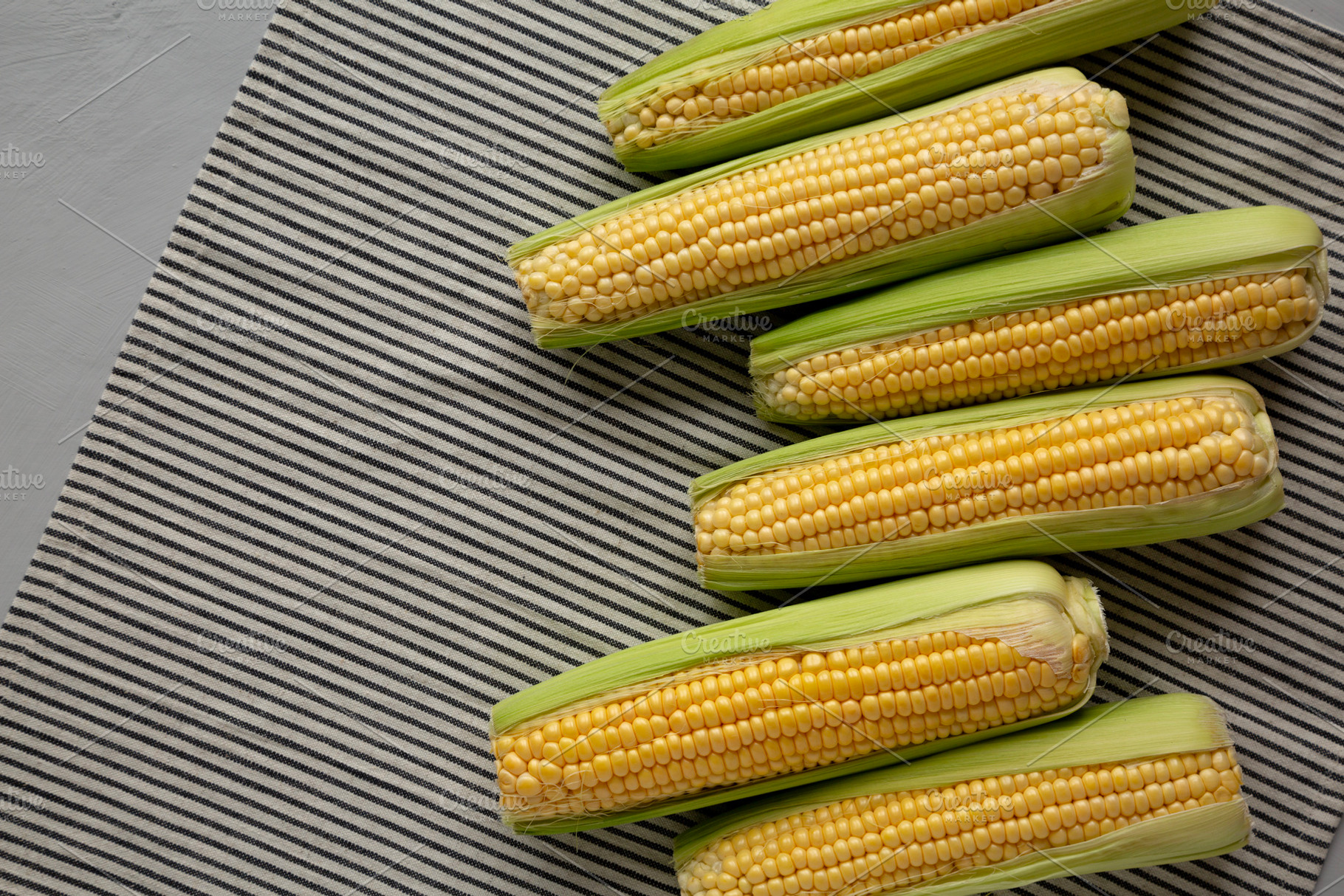 Fresh Raw Organic Corn on the Cob in the Husk, top view. Copy sp, a Food & Drink Photo by LiudmylaChuhunova