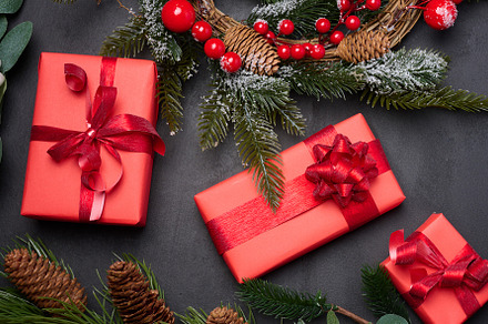Christmas wreaths, fir branches and gifts on a black background., a Holiday Photo by ndanko