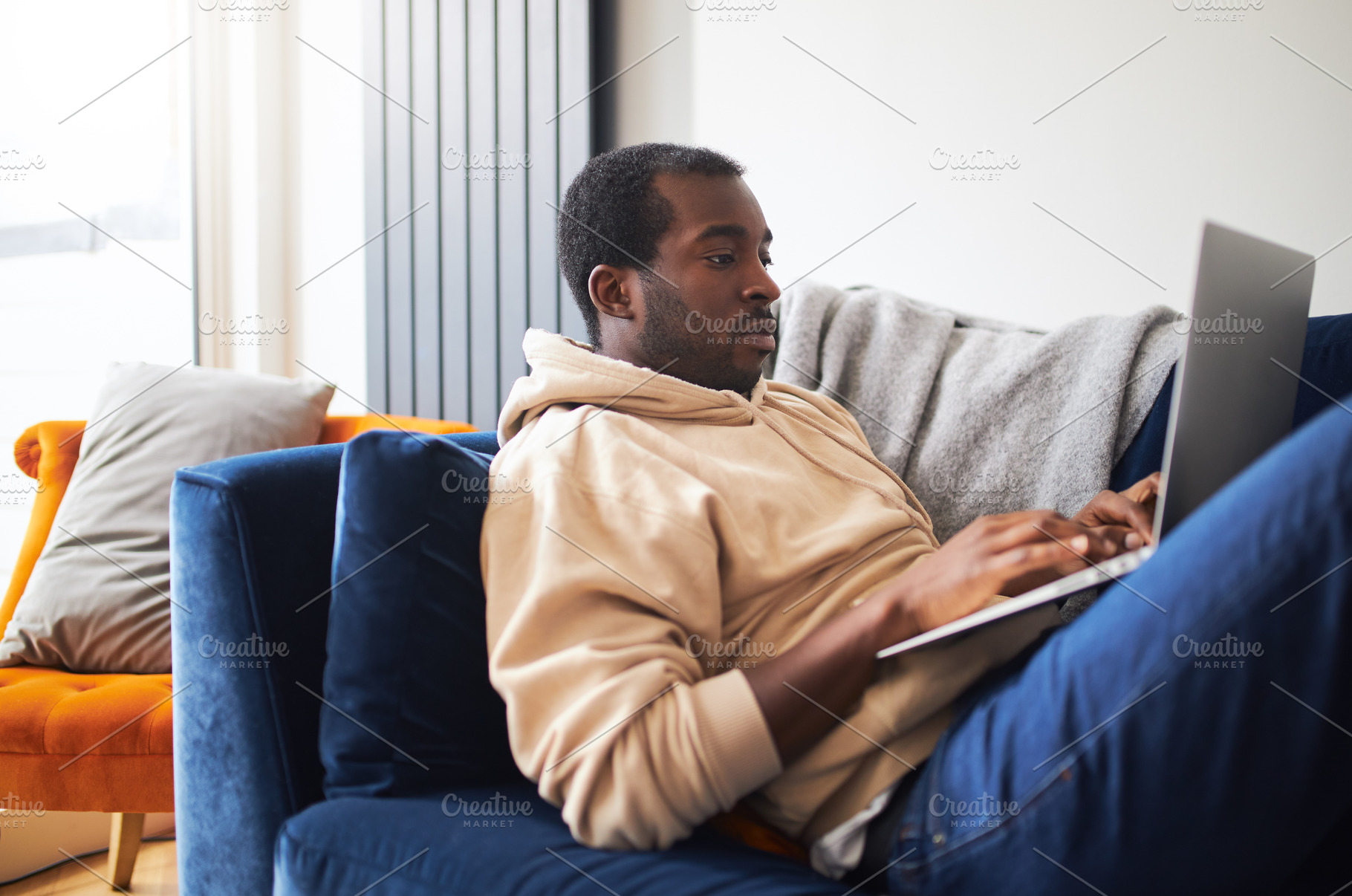 Young Man Relaxing At Home Lying On Sofa Using Laptop To Work From Home Or Shop, a Photo by Southworks