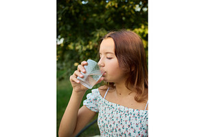 Girl drinks clear water from glass