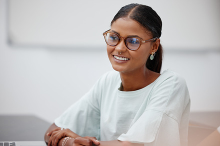 Woman, student and classroom focus with smile at college in lecture for education, learning and training. Girl, glasses and happy at school, university or class for lesson, study or scholarship, a Photo by Peopleimages.com