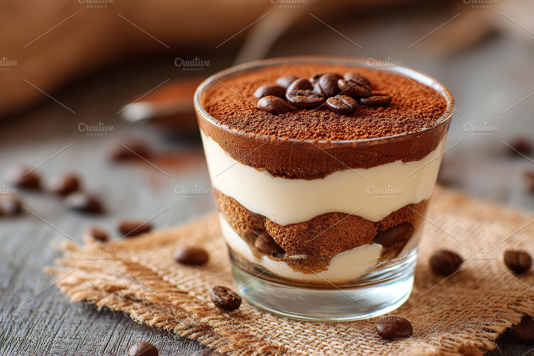 Tiramisu dessert in a glass with cocoa and coffee beans on wooden table, a Food & Drink Photo by AlyaAnd