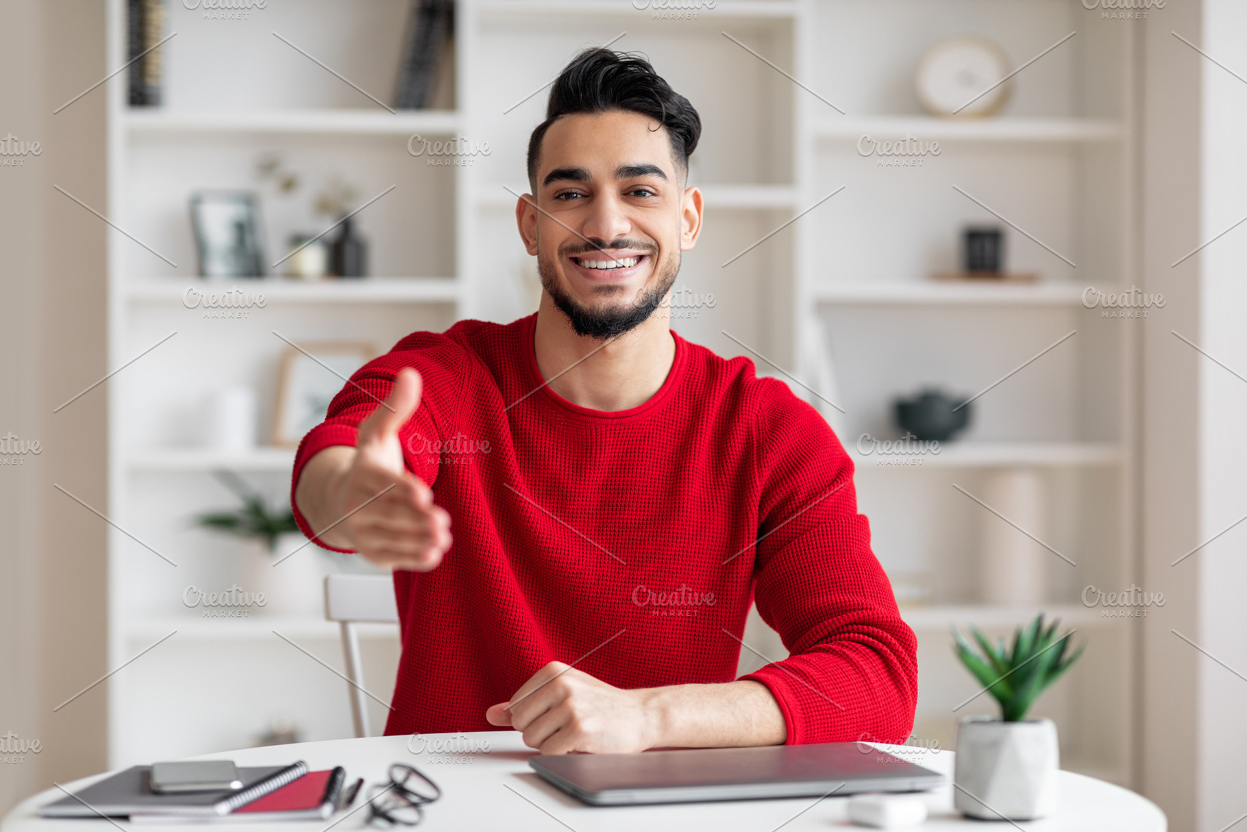 Cheerful friendly attractive young arab businessman with beard in red clothes g, a Photo by Prostock-Studio