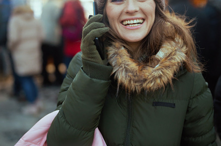 happy woman at christmas fair in city talking on phone, a Holiday Photo by Alliance Images